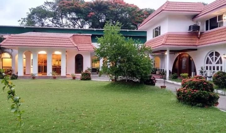 Red-tiled colonial building and lawn at ATS Willingdon Hotel