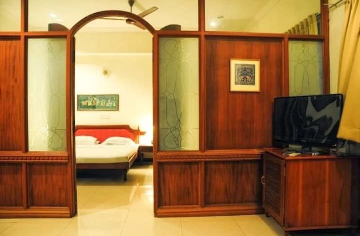 Suite bedroom with wooden partition at ATS Willingdon Hotel